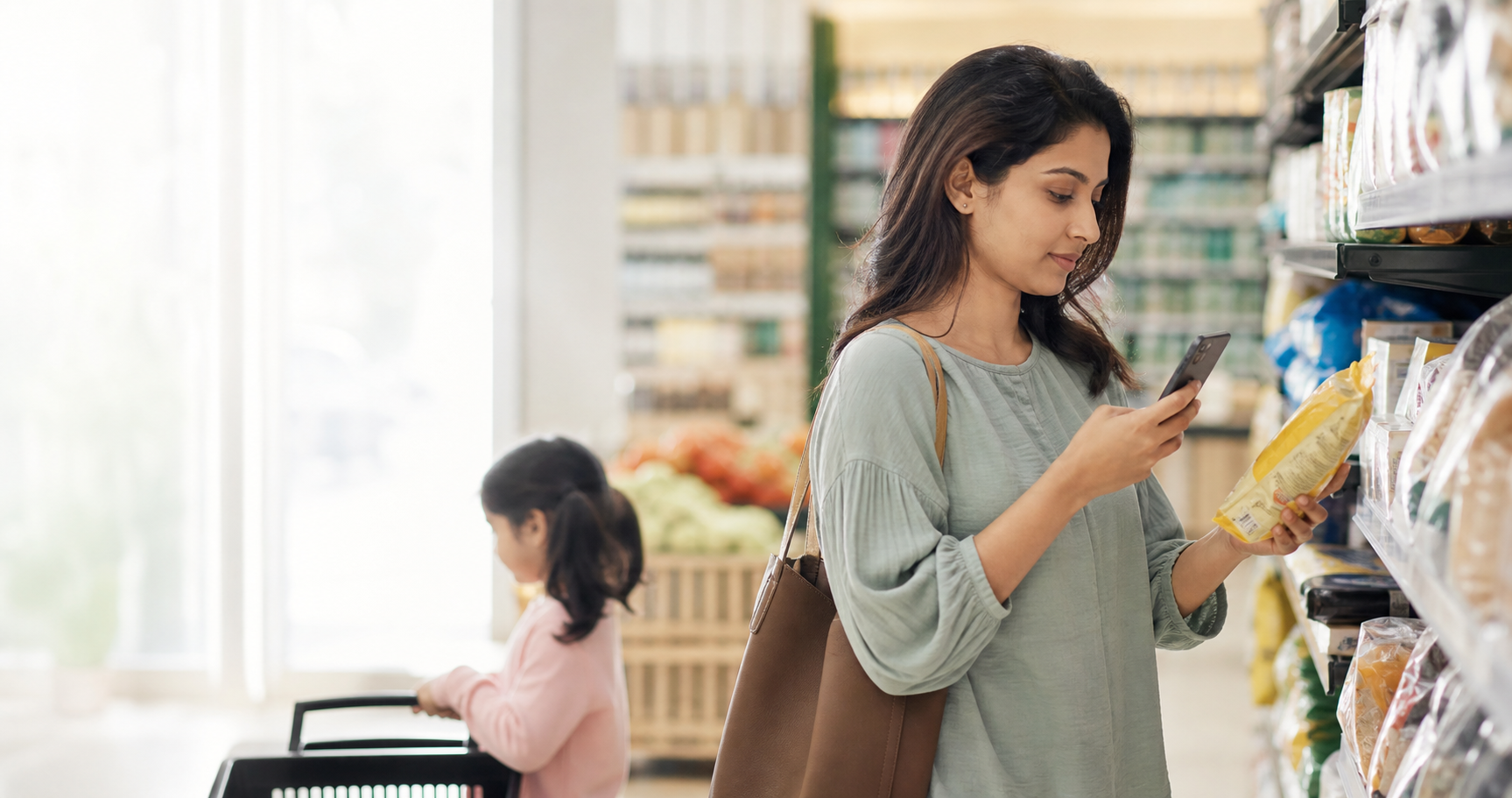 A parent using a phone to read a product label while shopping with her child